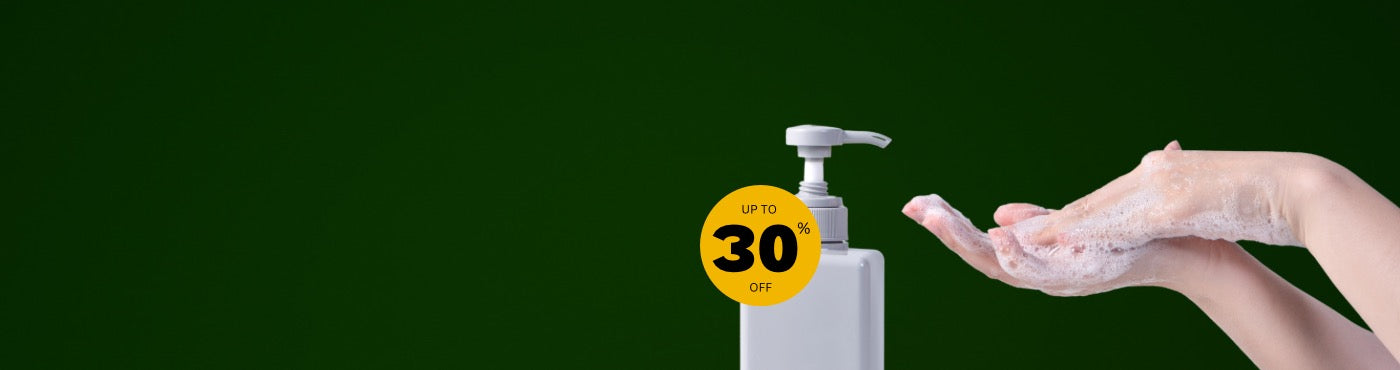 Person lathering soap on hands from dispenser with 30 percent off seal on green background